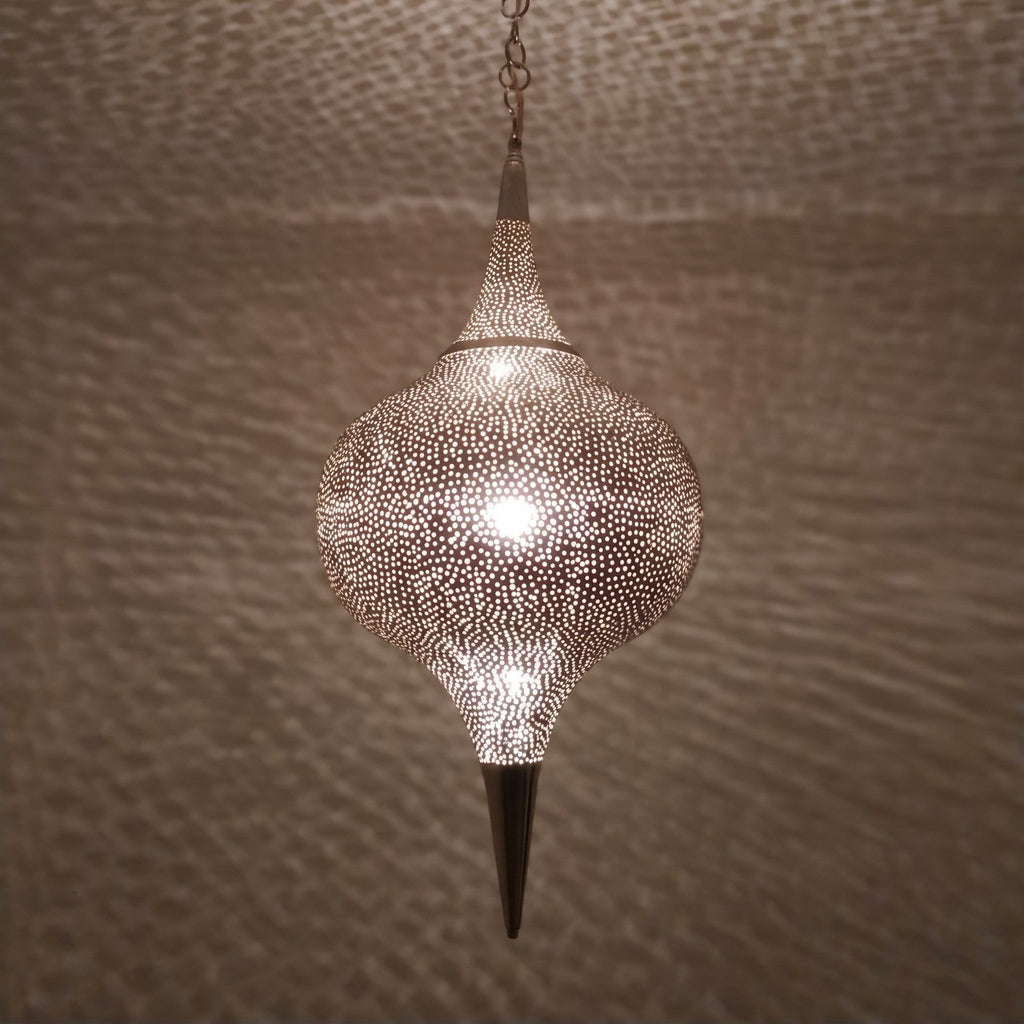 Close detail of the lit Aksil, warm light through hand-punched circles