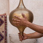 The Aksil shade held in the maker's hands, punch marks visible
