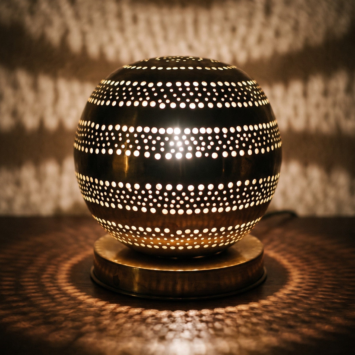 Close view of the lit Aman lamp, light escaping through hand-cut perforations