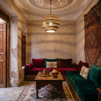 Amanar pendant lit in a Moroccan riad, floral shadows on the walls
