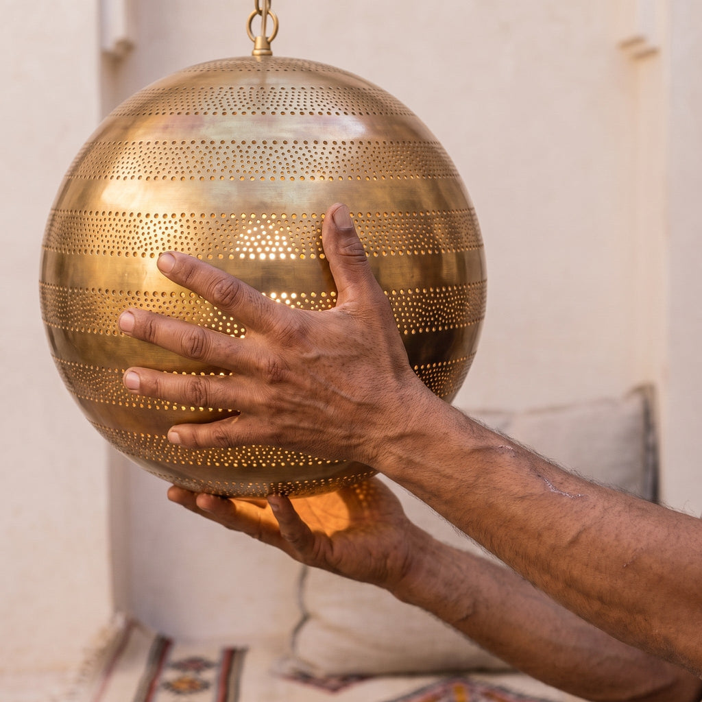 The Amanar dome held in the maker's hands, piercing work visible up close