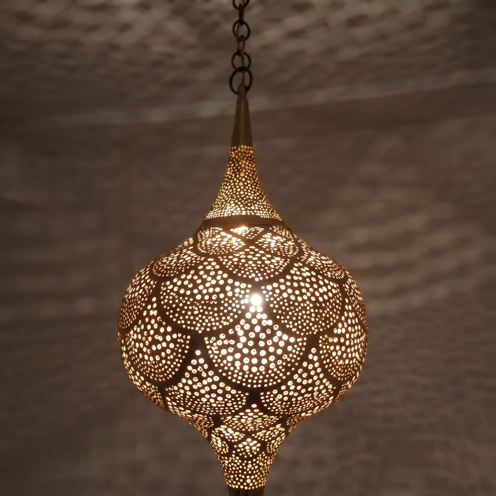 Lit Amira pendant in close-up, light spilling through wide pierced cutouts