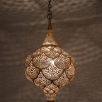 Lit Amira pendant in close-up, light spilling through wide pierced cutouts