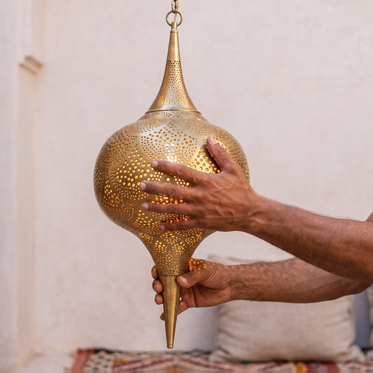 The Amira shade held in the maker's hands in the Marrakech workshop