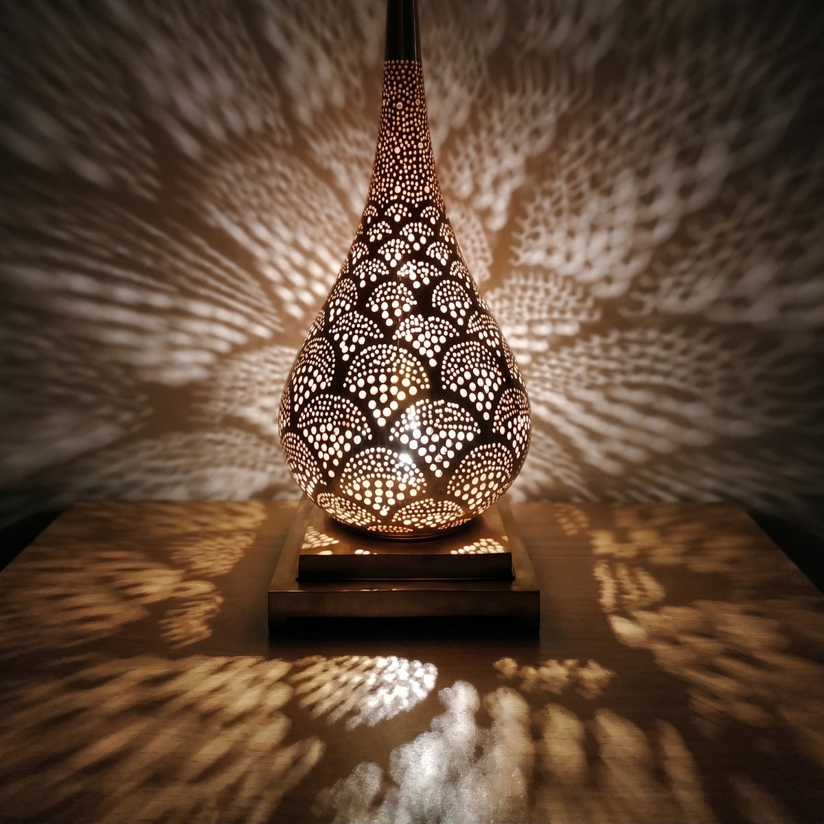 Detail of the lit Anbar lamp, amber light through hand-cut brass piercing