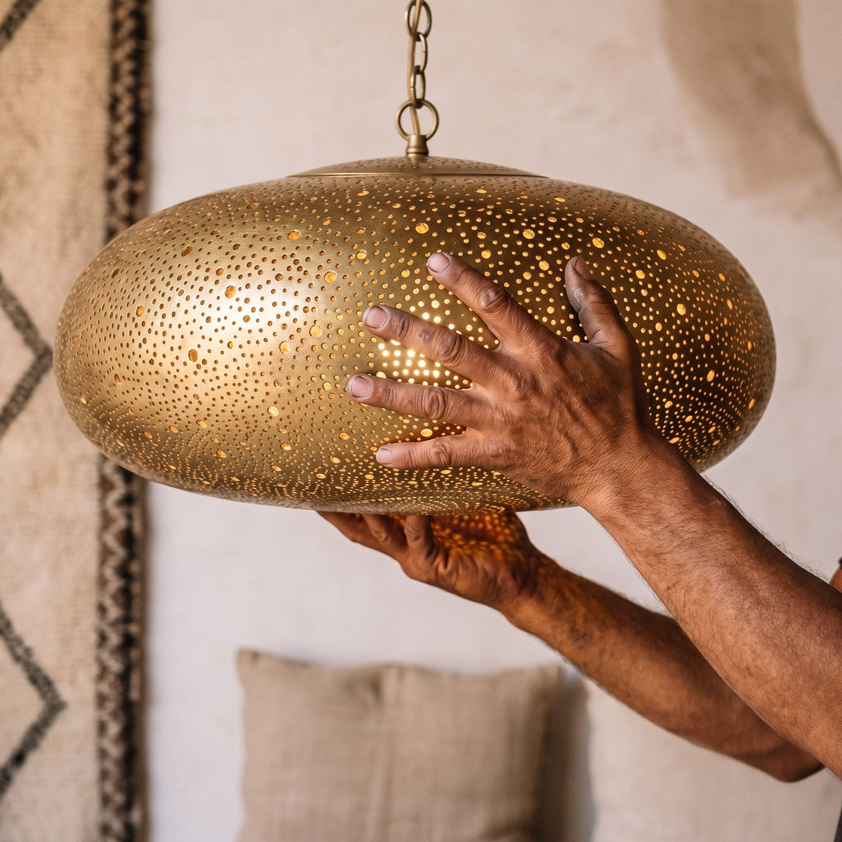 A maker's hands holding the Anfa dome, piercing visible up close