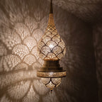 Close view of the lit Asafu, pattern glowing through pierced brass