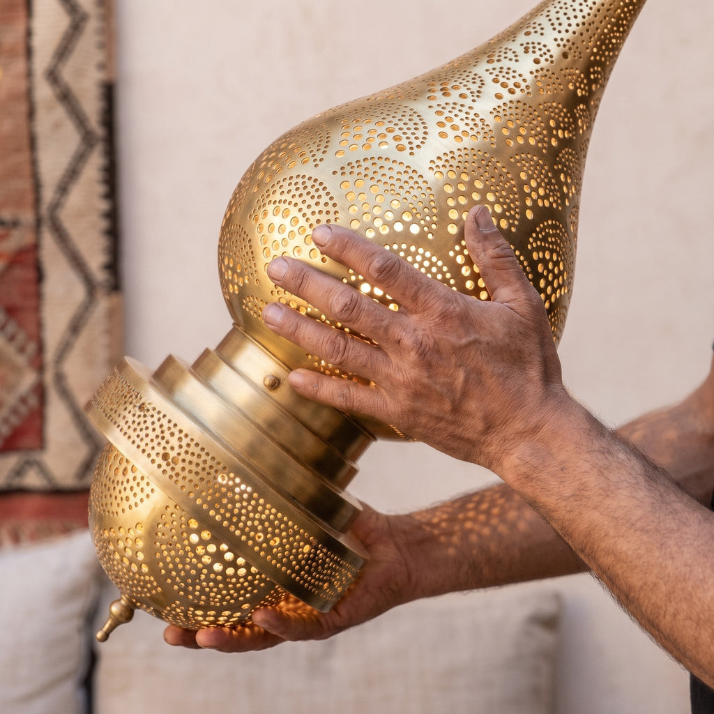 A maker's hands steadying the tall Asafu body in the workshop