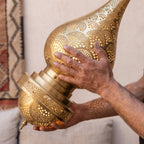 A maker's hands steadying the tall Asafu body in the workshop