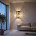 Aya brass sconce with pierced Arabic calligraphy on a modern living room wall