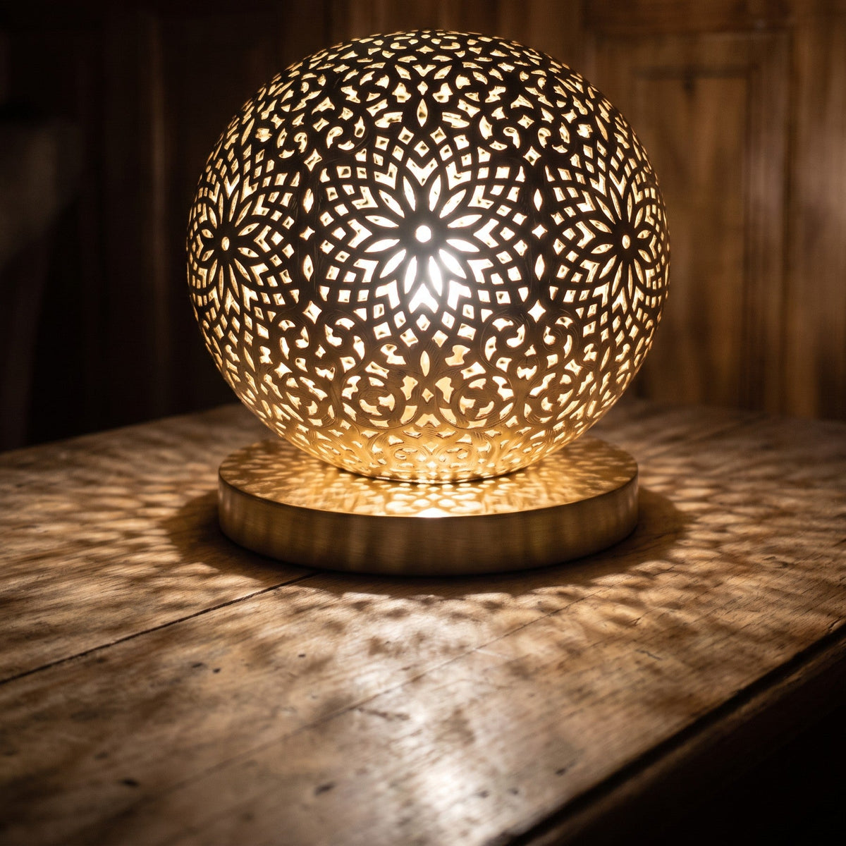 Close view of the lit Ayyur sphere, engraving and pierced openings glowing