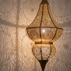 Detail of the lit Badi, floral motifs glowing through the brass