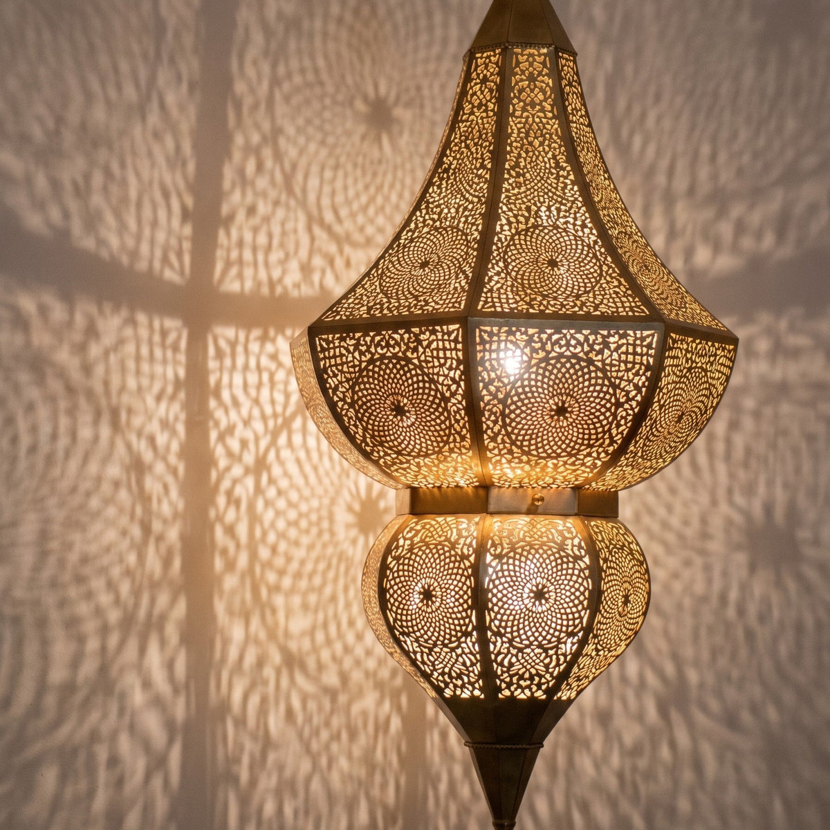 Detail of the lit Badi, floral motifs glowing through the brass
