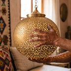 A maker's hands holding the unfinished Bahia dome in the workshop