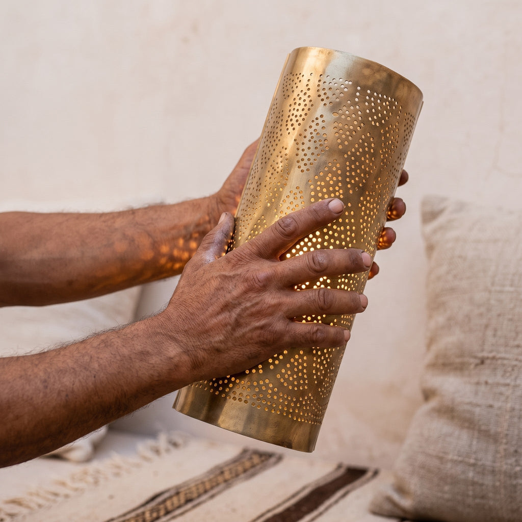Artisan holding one Bahja pierced brass sconce shade in both hands
