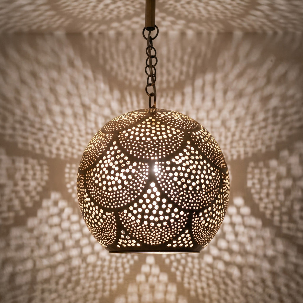 Detail of the lit Chourouk pendant, punched circles glowing