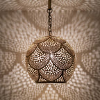 Detail of the lit Chourouk pendant, punched circles glowing