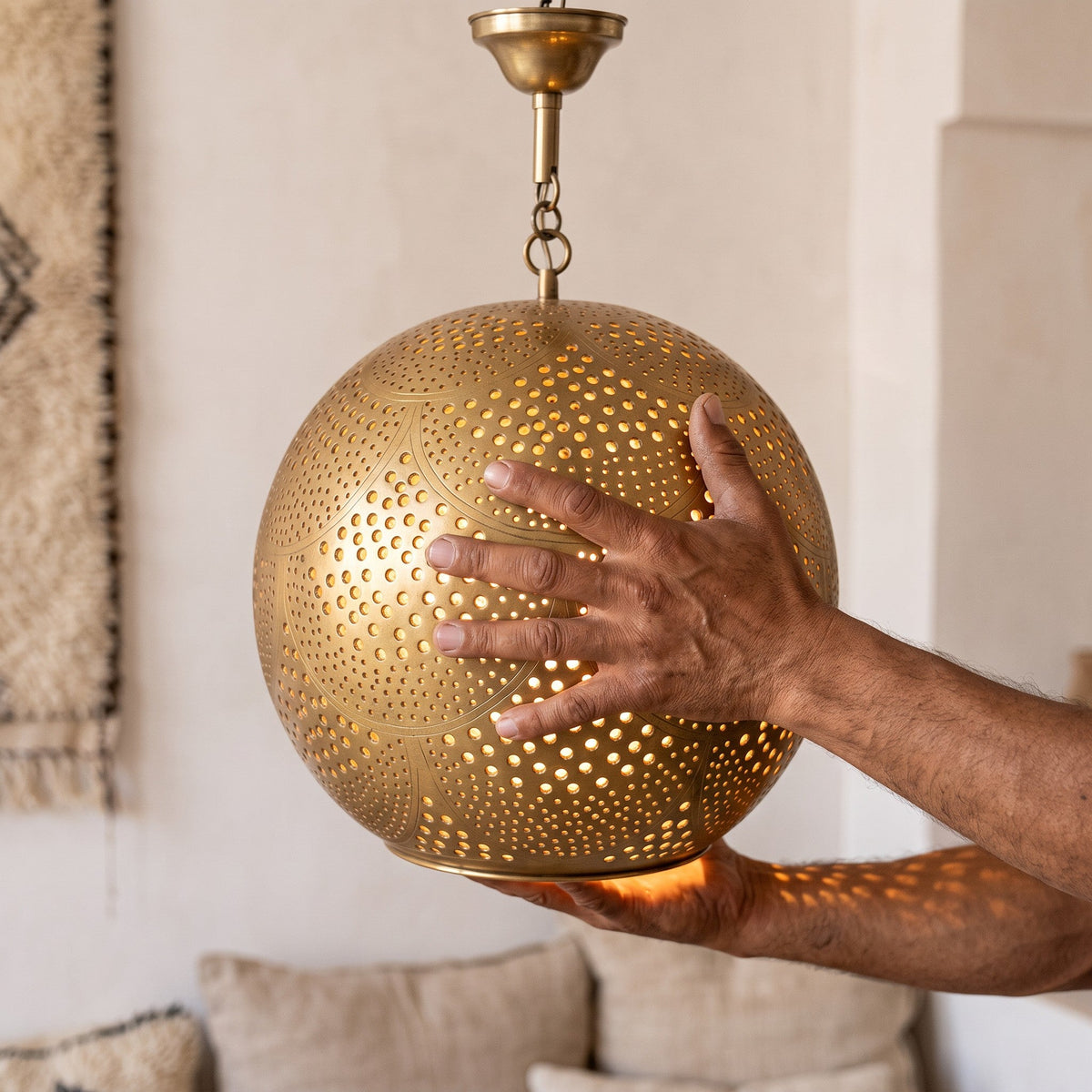 The Chourouk brass ball held in the maker's hands before finishing