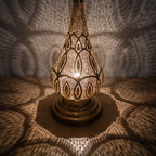 Close-up of Dahab lit, the pierced brass pattern glowing from within