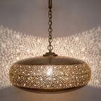 Detail of the lit Dihya pendant showing light through a pierced floral band