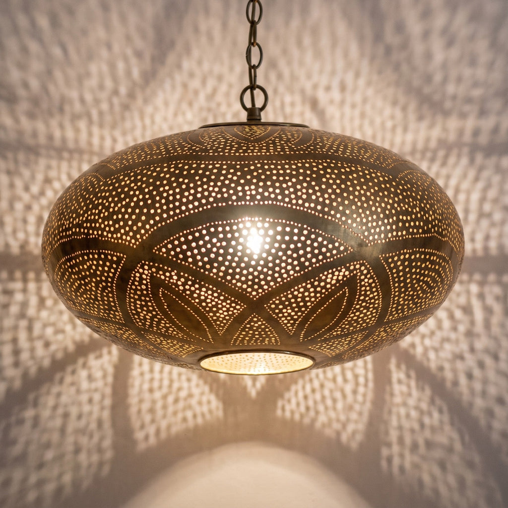 Detail of the Hana pendant lit, glow breaking through the piercing