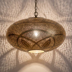 Detail of the Hana pendant lit, glow breaking through the piercing