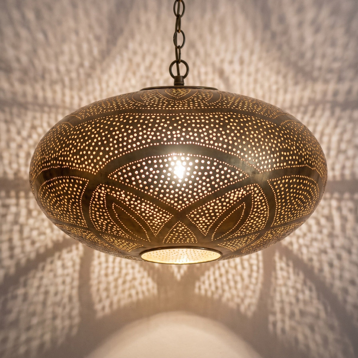 Detail of the Hana pendant lit, glow breaking through the piercing