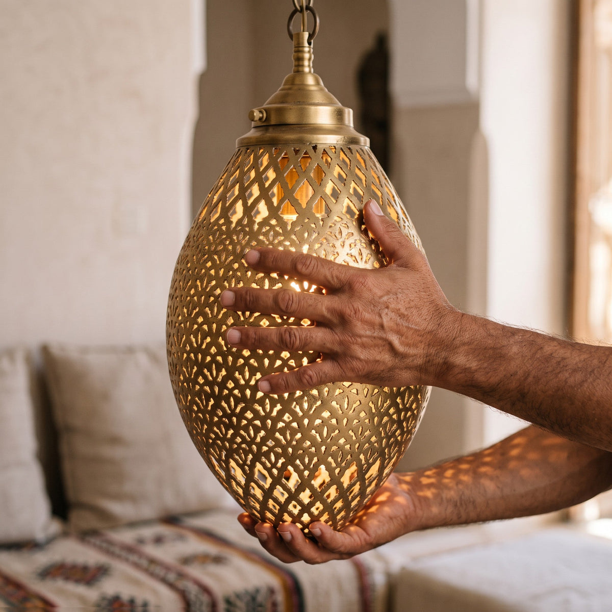 The Kenza egg held in the maalem's hands, chisel work visible