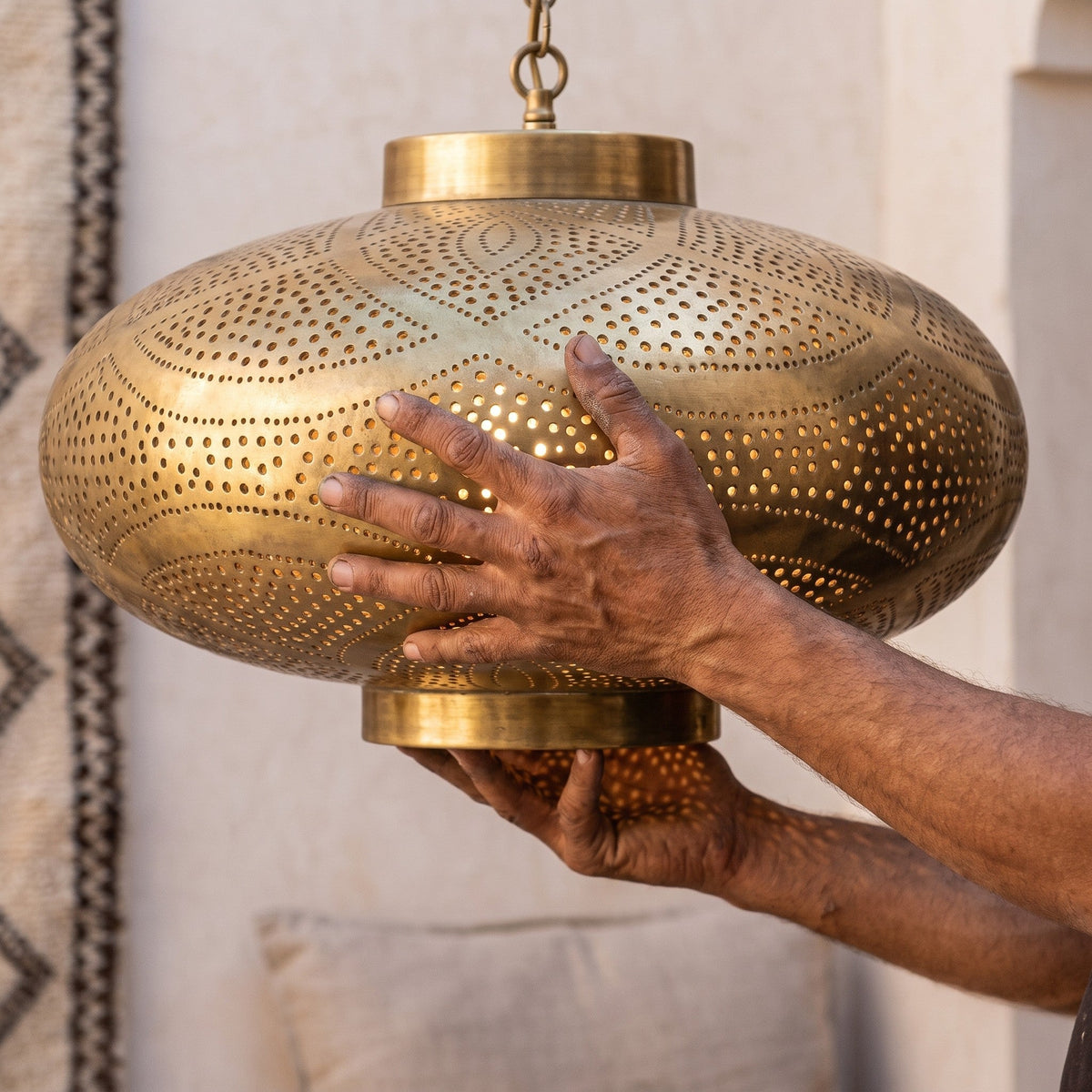 A maalem holding the Layla shade in both hands, piercings visible
