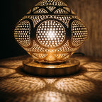 Detail of the lit Louiza dome, pattern of light through pierced brass