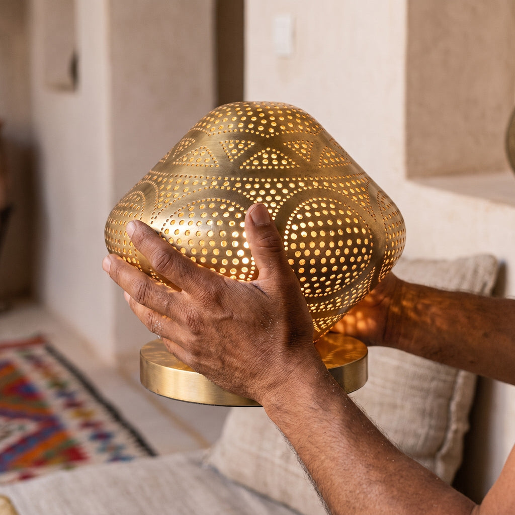 A maalem holds the small Louiza dome in both hands at the workshop