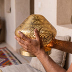 A maalem holds the small Louiza dome in both hands at the workshop