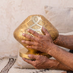 The maker's hands cupping the small Louz dome in the workshop
