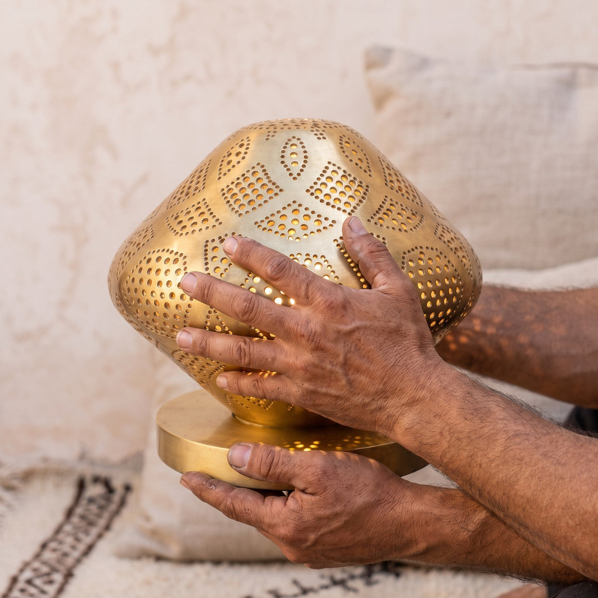 The maker's hands cupping the small Louz dome in the workshop