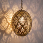 Detail of the lit Massa pendant, punched circles sparkling