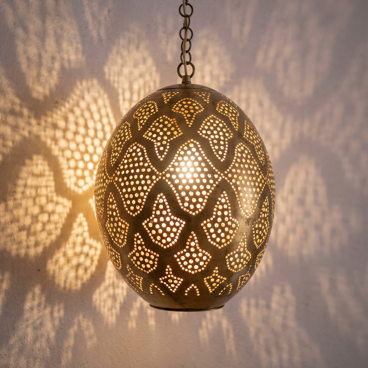 Detail of the lit Massa pendant, punched circles sparkling