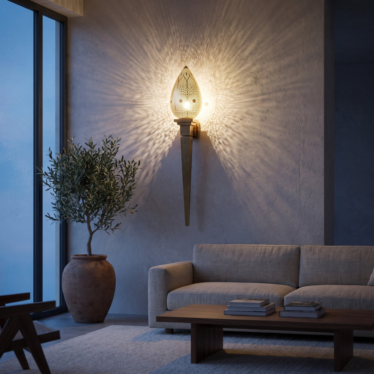 Menara brass wall sconce mounted on a plain wall in a modern living room