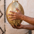 Maker's hands holding the Merzouga lantern in the workshop