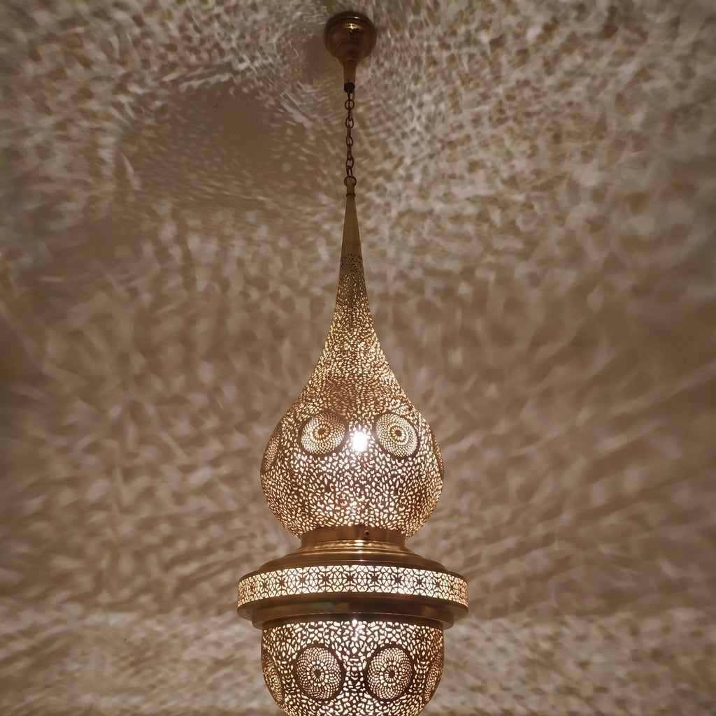 Lit Mgoun in close-up, patina and pierced motifs catching the light