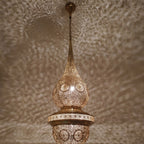 Lit Mgoun in close-up, patina and pierced motifs catching the light