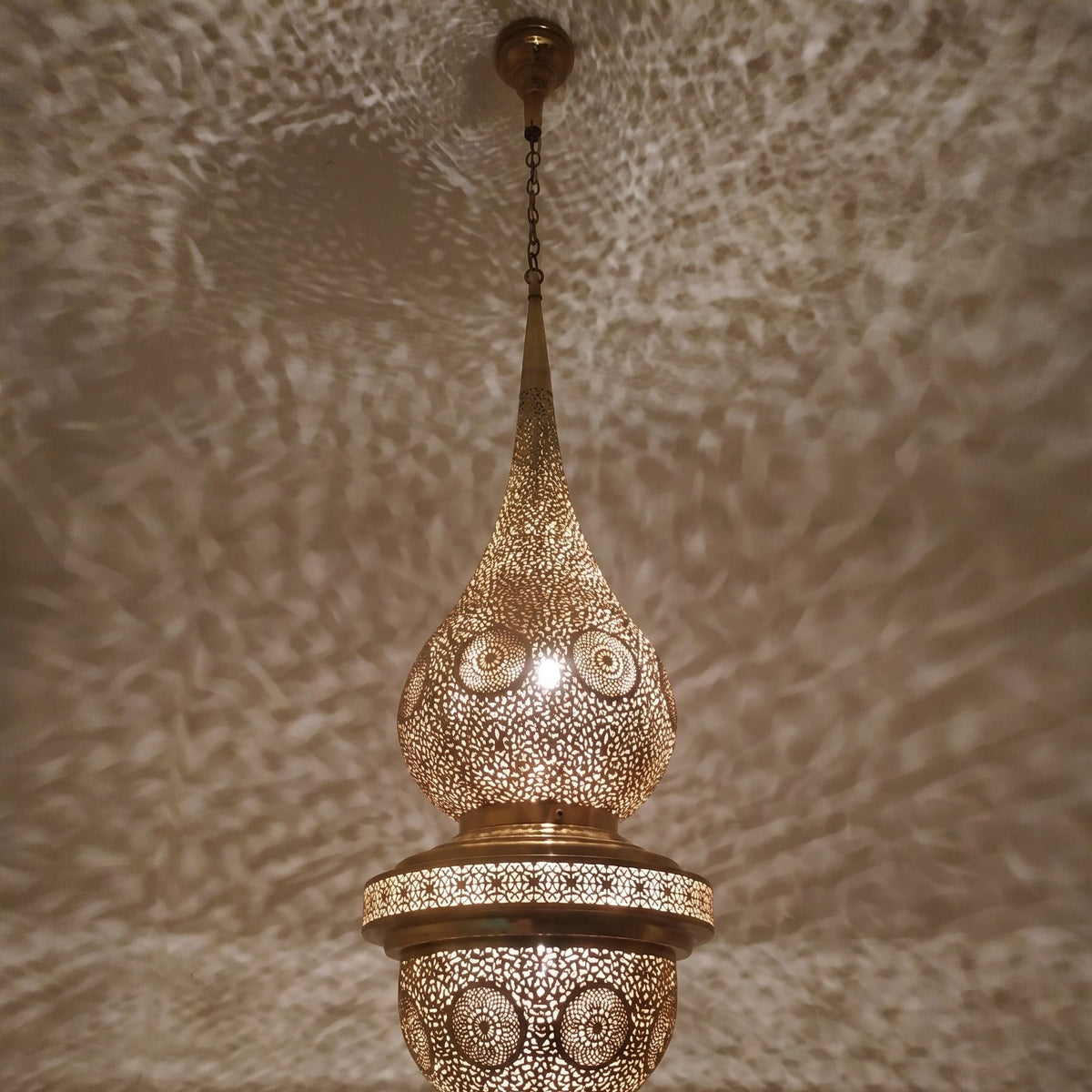 Lit Mgoun in close-up, patina and pierced motifs catching the light