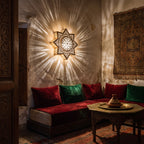 Najma sconce casting patterned light on a Moroccan riad wall