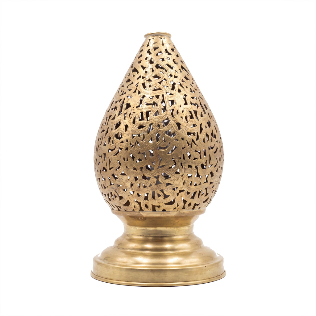 Naqsh brass table lamp pierced with Arabic calligraphy, on a white studio background