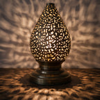Detail of the lit Naqsh lamp, light passing through hand-cut Arabic letters