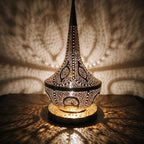 Detail of Nassim lit, small pierced openings glowing in the brass column