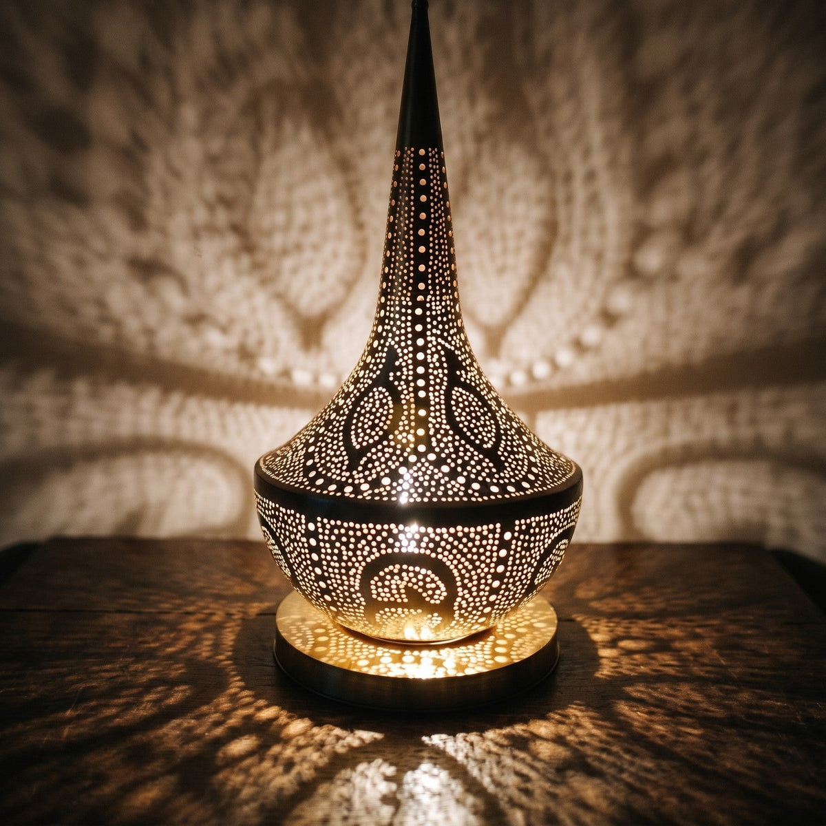 Detail of Nassim lit, small pierced openings glowing in the brass column