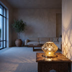 Nouara lantern lit on a bedside table in a modern bedroom