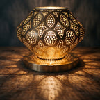 Close view of the lit Nouara, light escaping between the parted brass petals