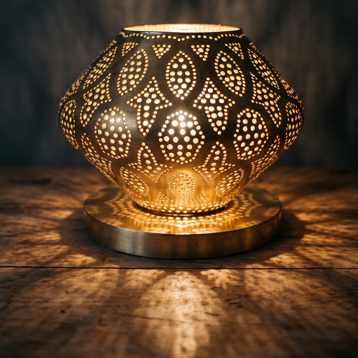 Close view of the lit Nouara, light escaping between the parted brass petals