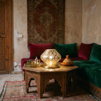 Nouara lantern glowing on a low table in a Moroccan riad